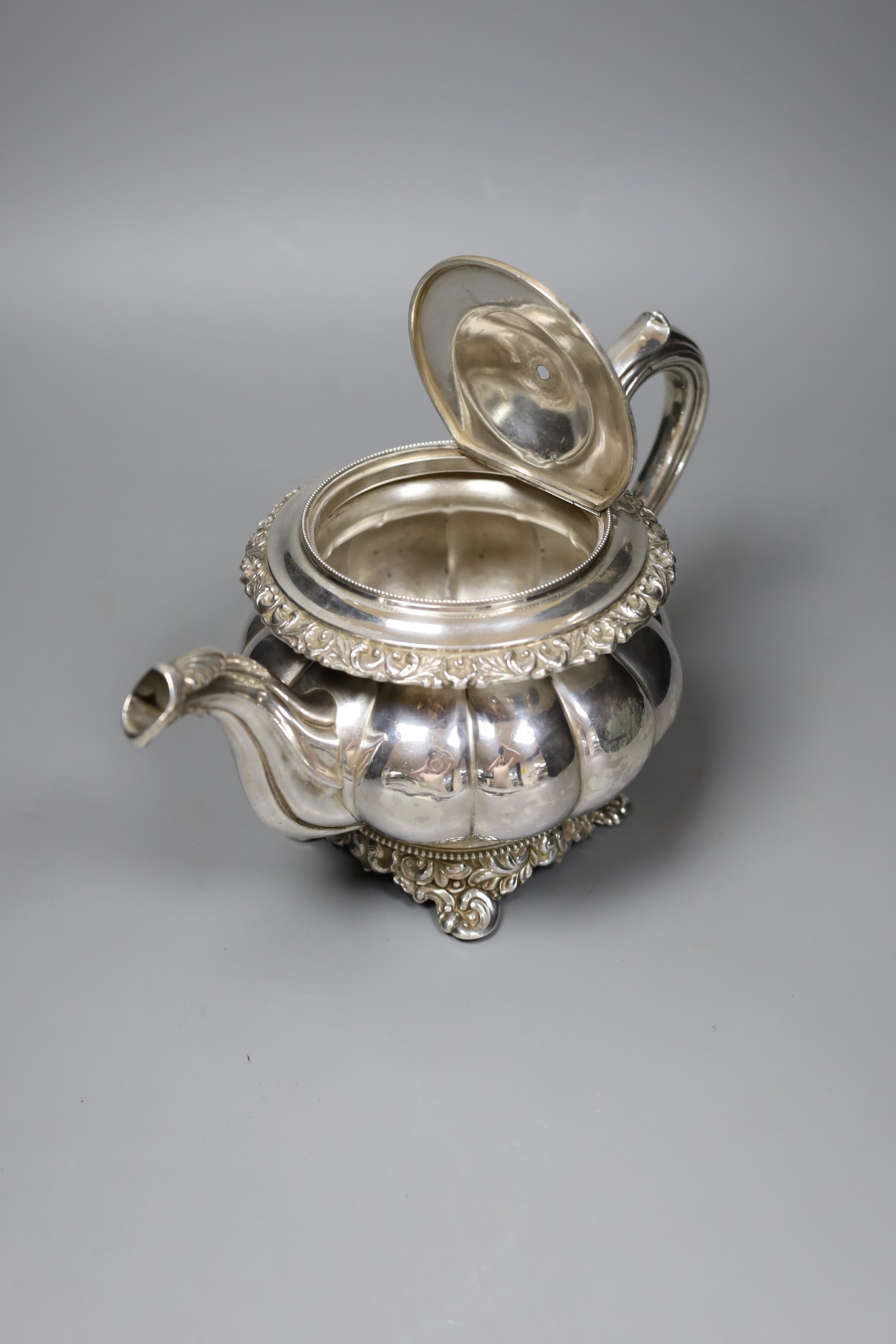 A 19th century Continental white metal teapot, with fruit finial, bone isolators and scroll feet, (a.f.), gross 24 oz.